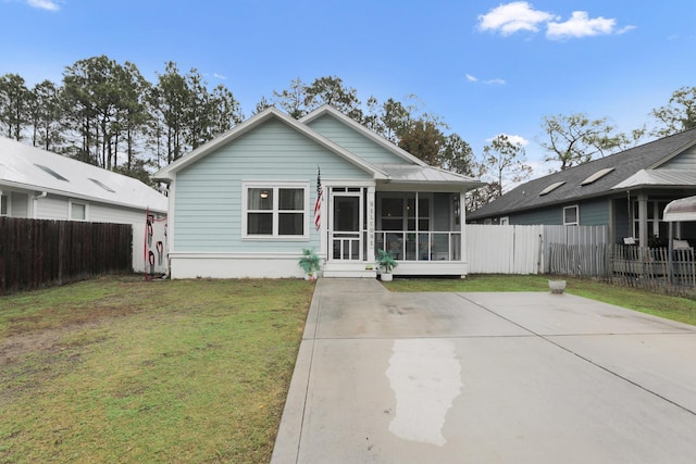 bungalow-style home with a sunroom and a front lawn