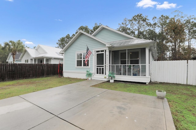 view of front facade with a sunroom and a front lawn