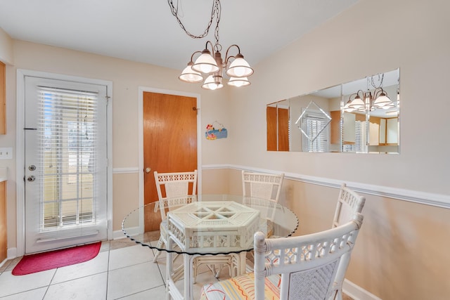 dining space with tile patterned floors and an inviting chandelier