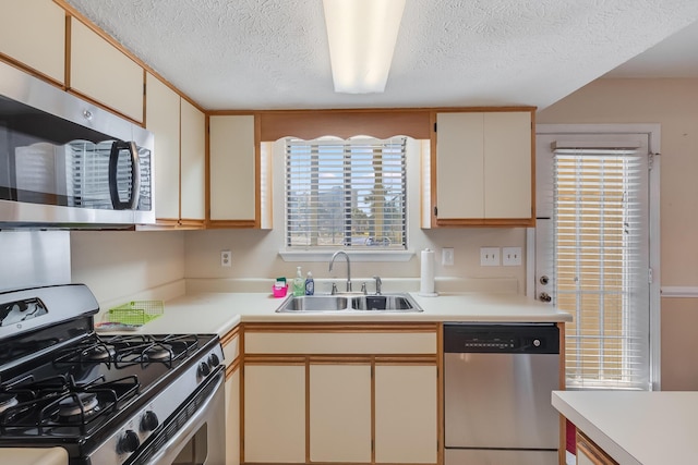 kitchen featuring a textured ceiling, sink, and appliances with stainless steel finishes