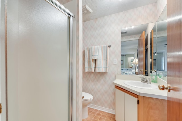 bathroom featuring vanity, tile patterned floors, toilet, a textured ceiling, and walk in shower