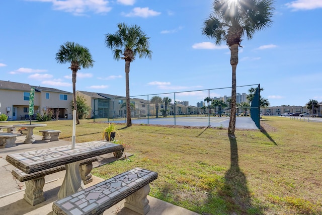 view of community featuring a yard and tennis court