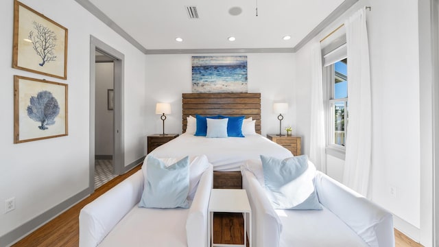 bedroom featuring crown molding and light hardwood / wood-style flooring