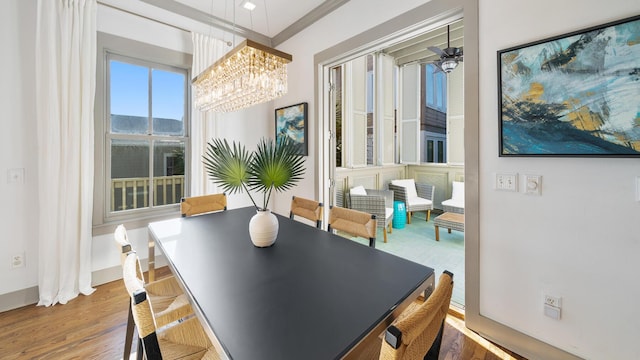 dining room with hardwood / wood-style flooring and ceiling fan with notable chandelier