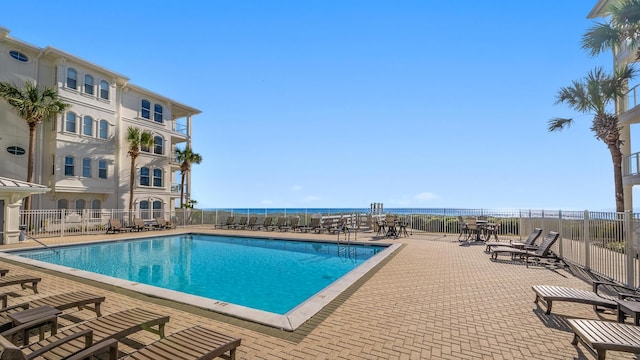 view of pool with a patio area and a water view