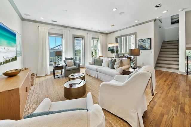 living room with light hardwood / wood-style flooring and crown molding