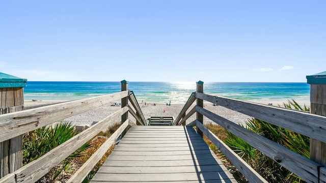 surrounding community with a water view and a beach view