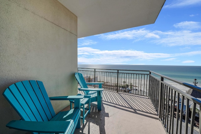 balcony with a water view and a view of the beach