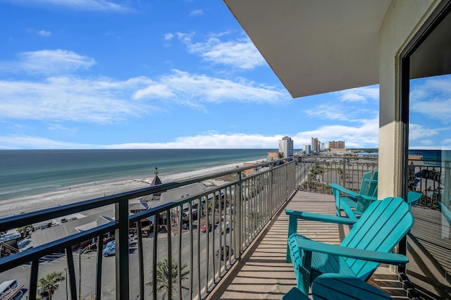 balcony with a water view and a view of the beach