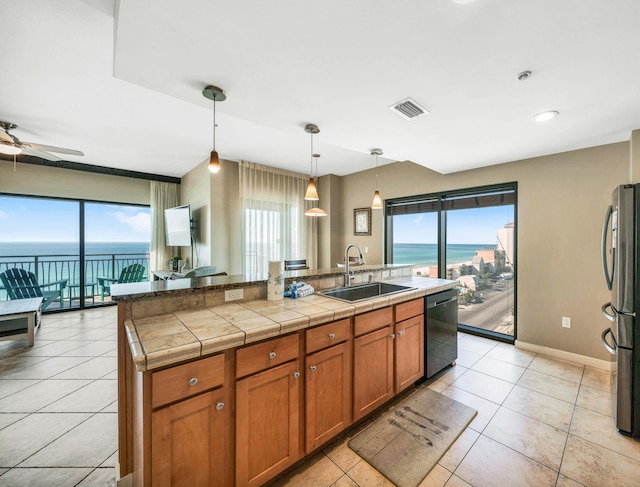 kitchen featuring ceiling fan, sink, hanging light fixtures, black dishwasher, and stainless steel fridge