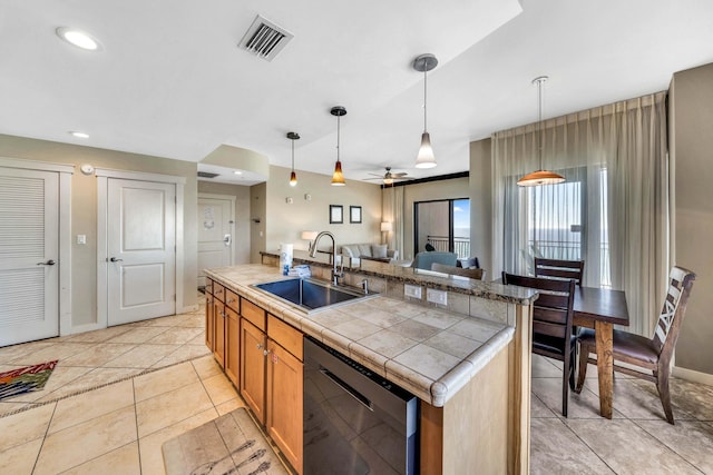 kitchen with stainless steel dishwasher, ceiling fan, sink, a center island with sink, and hanging light fixtures