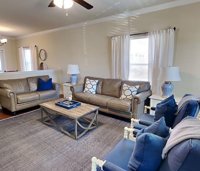 living room featuring hardwood / wood-style floors, a healthy amount of sunlight, ceiling fan with notable chandelier, and ornamental molding