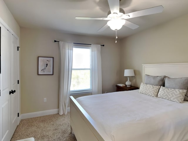 carpeted bedroom featuring ceiling fan and a closet