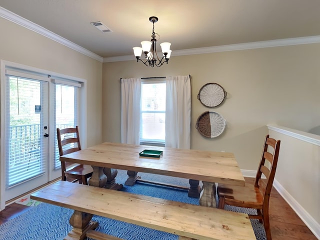 dining area with french doors, an inviting chandelier, ornamental molding, and hardwood / wood-style floors