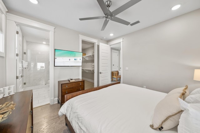 bedroom with a walk in closet, ensuite bath, ceiling fan, dark hardwood / wood-style floors, and a closet