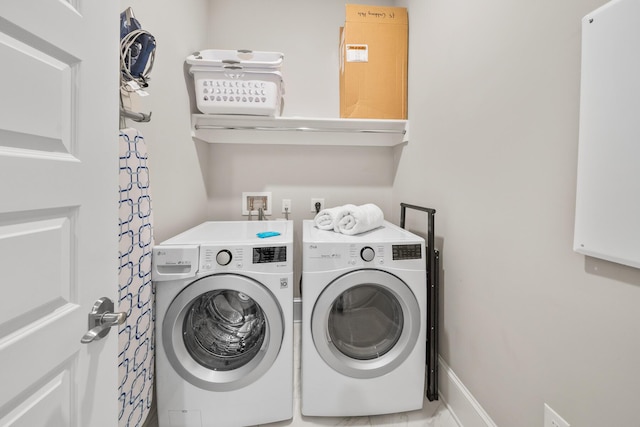 clothes washing area with washing machine and dryer