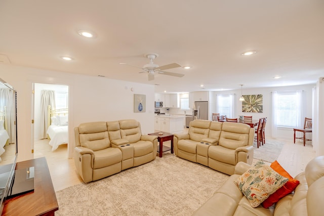 living room with light wood-type flooring and ceiling fan