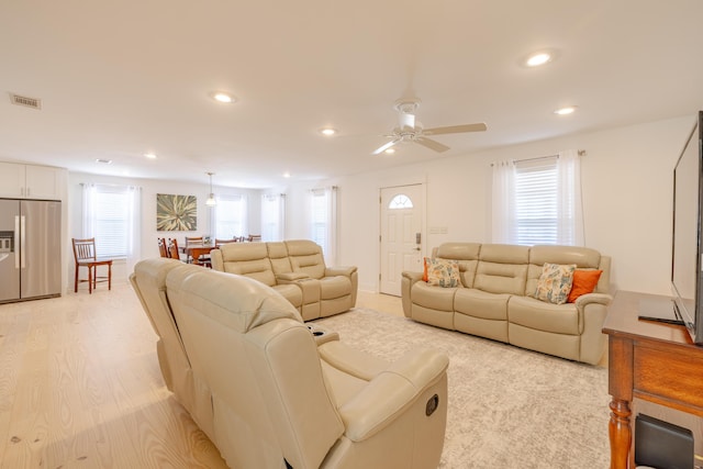 living room featuring ceiling fan and light hardwood / wood-style floors