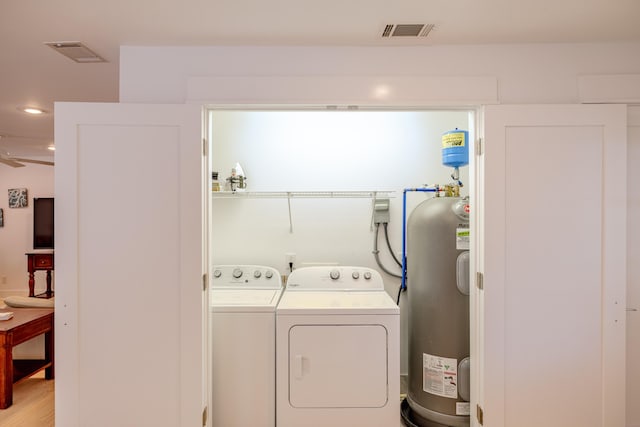 laundry area featuring washing machine and clothes dryer, ceiling fan, and water heater