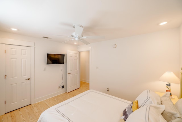 bedroom featuring ceiling fan, a closet, and light wood-type flooring