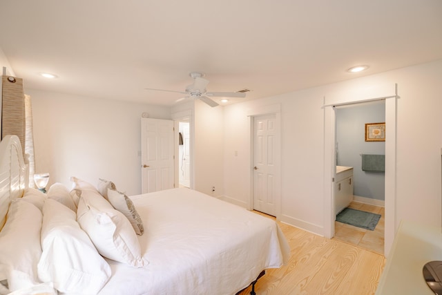 bedroom with connected bathroom, light hardwood / wood-style flooring, and ceiling fan