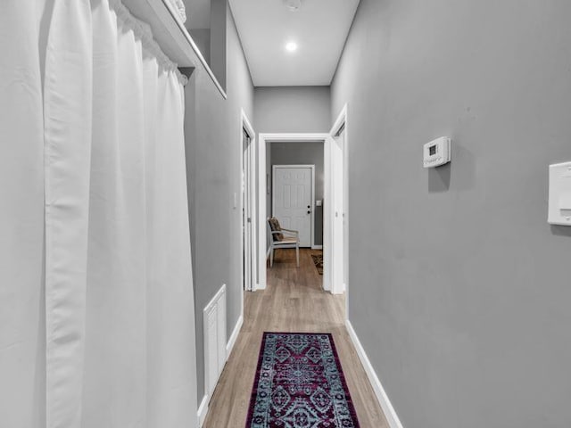 corridor with hardwood / wood-style floors