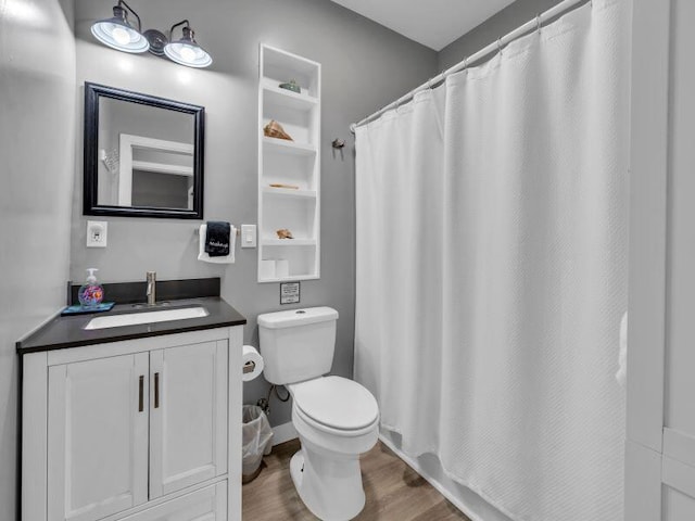 bathroom with toilet, wood-type flooring, curtained shower, and vanity