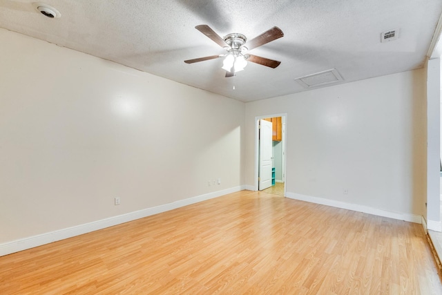 unfurnished room featuring ceiling fan, light wood-type flooring, and a textured ceiling