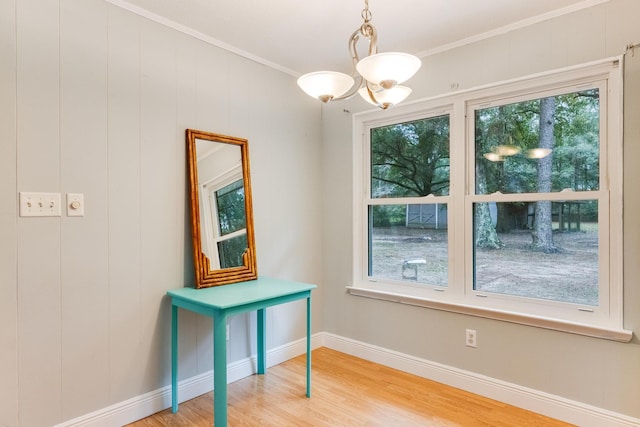 interior space featuring hardwood / wood-style floors, an inviting chandelier, and ornamental molding