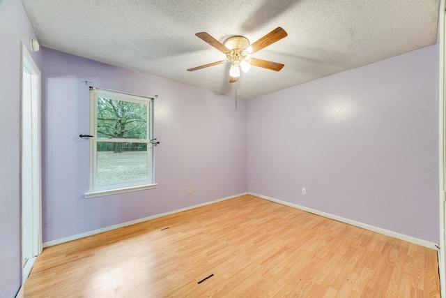 empty room with ceiling fan, light hardwood / wood-style flooring, and a textured ceiling