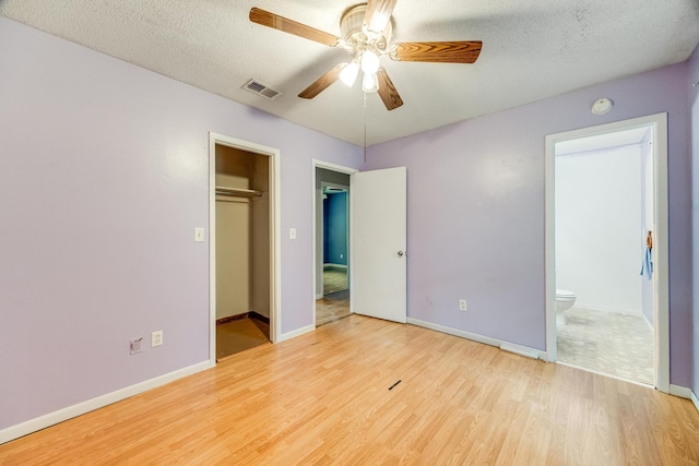 unfurnished bedroom with a closet, a textured ceiling, light hardwood / wood-style floors, and ceiling fan