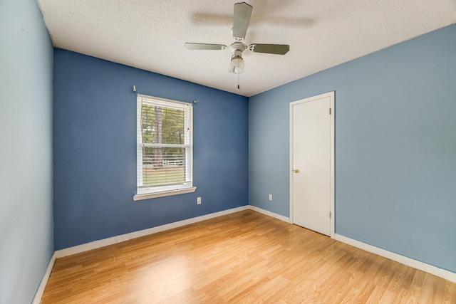 unfurnished room with ceiling fan, hardwood / wood-style floors, and a textured ceiling