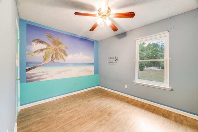 unfurnished room with ceiling fan, a textured ceiling, and hardwood / wood-style flooring