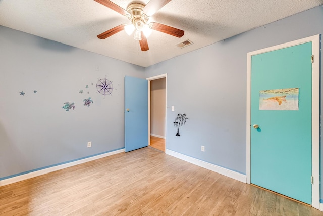 spare room featuring ceiling fan, a textured ceiling, and light wood-type flooring