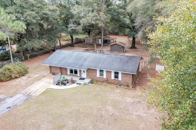 view of front of home featuring a front yard and a storage shed