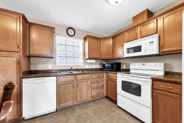 kitchen with a textured ceiling, sink, light tile patterned flooring, and white appliances