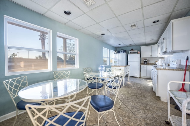 dining space with a drop ceiling