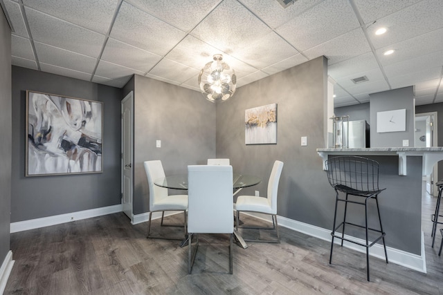 dining space with a paneled ceiling and wood-type flooring