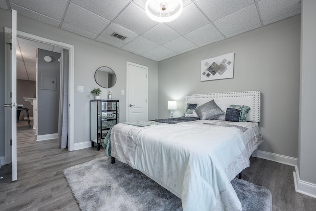 bedroom featuring hardwood / wood-style floors and a drop ceiling