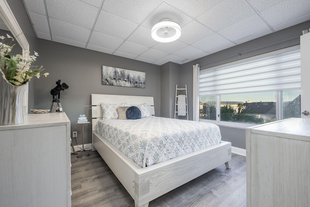 bedroom featuring a drop ceiling and wood-type flooring