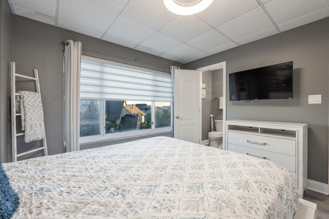 bedroom with hardwood / wood-style floors and a drop ceiling