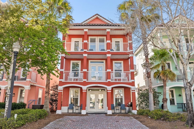 view of front of property featuring french doors, a tile roof, and stucco siding