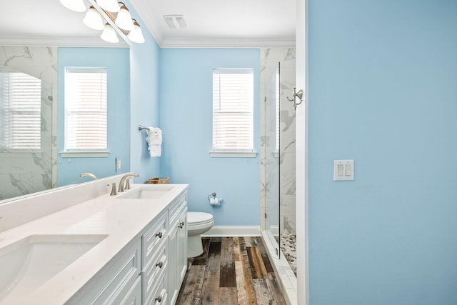 full bath featuring toilet, crown molding, a sink, and wood finished floors