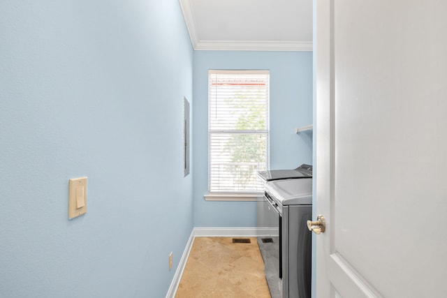 washroom featuring crown molding, visible vents, washing machine and dryer, laundry area, and baseboards