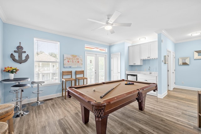 game room with plenty of natural light, crown molding, indoor wet bar, and french doors