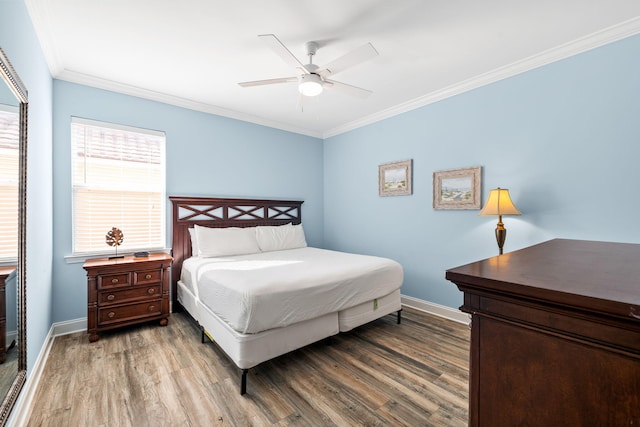 bedroom featuring ornamental molding, baseboards, and wood finished floors