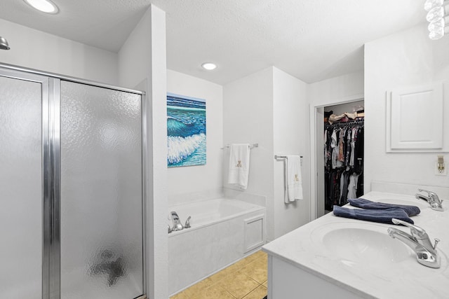 bathroom featuring a textured ceiling, tile patterned floors, vanity, and shower with separate bathtub