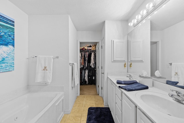 bathroom featuring a textured ceiling, vanity, a bathing tub, and tile patterned flooring