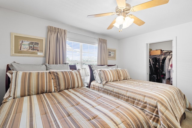 carpeted bedroom featuring a spacious closet, a closet, and ceiling fan