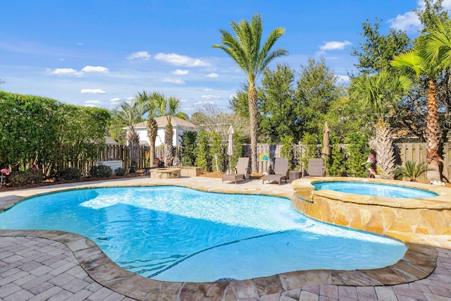 view of swimming pool featuring an in ground hot tub and a patio